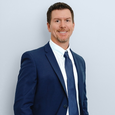 Dr. Gardner hedshot, in blue suit, smiling, with light gray background